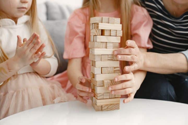 Familie spielt Geschicklichkeitsspiel Jenga