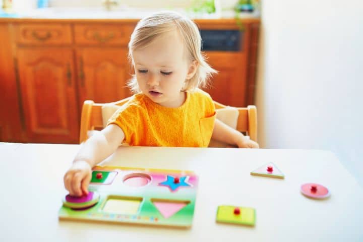 2-jähriges Kind am Tisch mit Puzzle