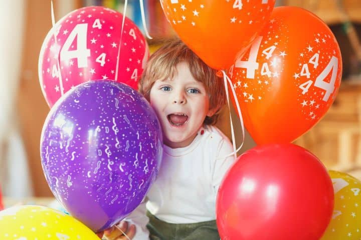 4 jähriges Kind feiert seinen 4.Geburtstag mit vielen bunten Luftballons