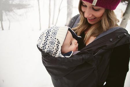 Mama trägt ihr Baby im Ergobaby Wintercover